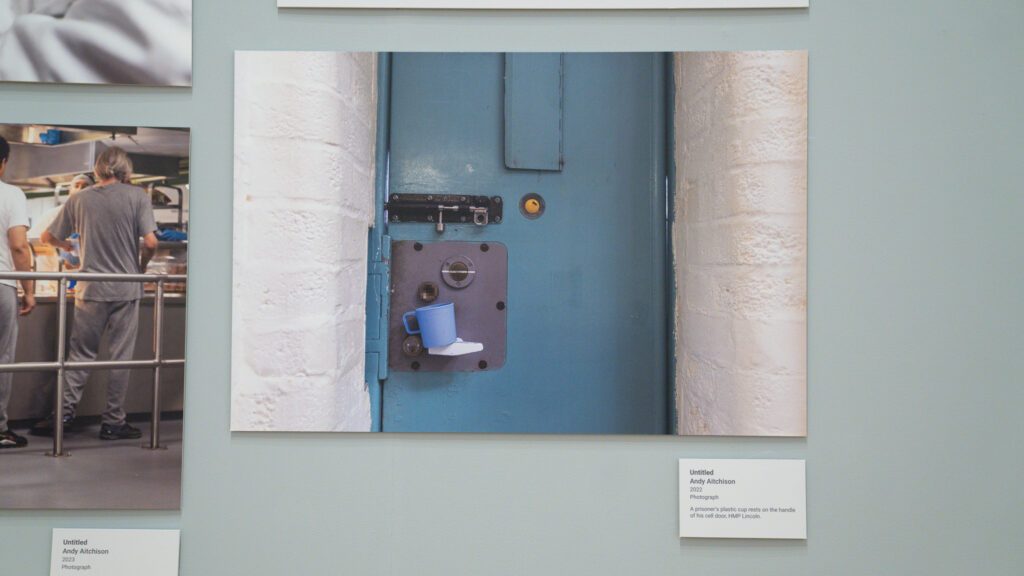A prisoner's plastic cup rests on the handle of his cell, HMP/YOI Lincoln, 2022.