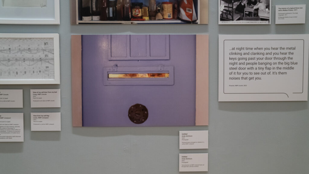 Two prisoners at HMP Liverpool look through out their cell door window, 2023.